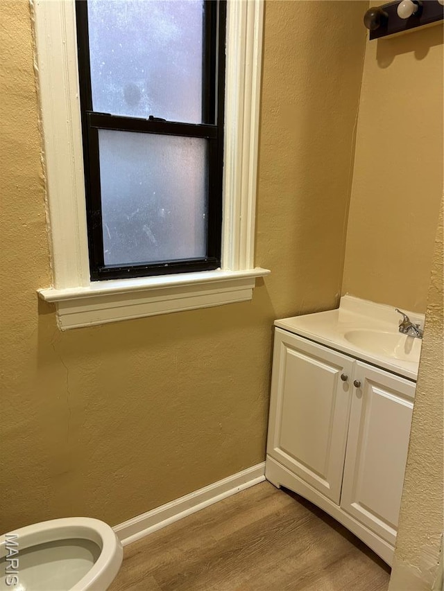 4844 Northland Ave, Saint Louis, MO 63113 - half bath featuring wood finished floors, vanity, a textured wall, toilet, and baseboards