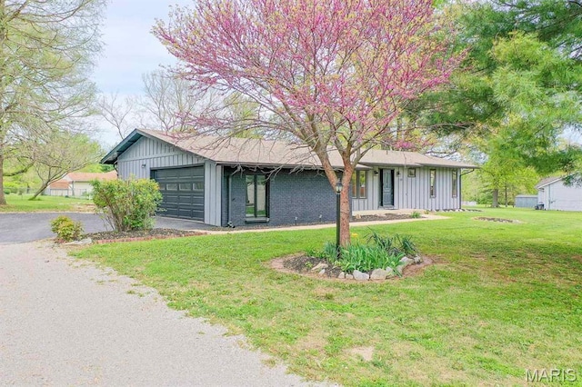 19 Ruth Ann Dr, Godfrey, IL 62035 - view of front of home featuring board and batten siding, an attached garage, a front lawn, and asphalt driveway