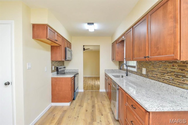 19 Ruth Ann Dr, Godfrey, IL 62035 - kitchen with appliances with stainless steel finishes, a sink, decorative backsplash, baseboards, and brown cabinetry