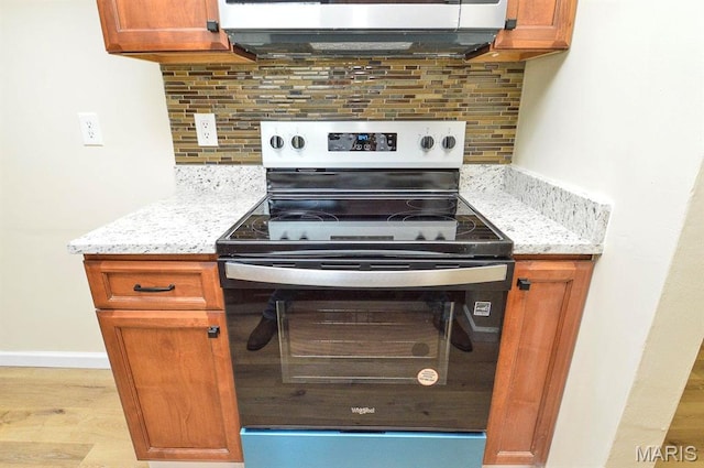 19 Ruth Ann Dr, Godfrey, IL 62035 - kitchen featuring stainless steel electric range, decorative backsplash, brown cabinets, light wood finished floors, and light stone countertops