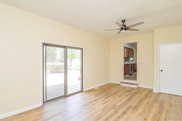 19 Ruth Ann Dr, Godfrey, IL 62035 - empty room featuring beverage cooler, light wood-style floors, baseboards, and a ceiling fan