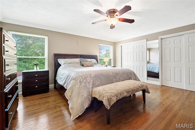12935 Topping Estates Dr, Town And Country, MO 63131 - bedroom featuring two closets, multiple windows, wood finished floors, and ornamental molding