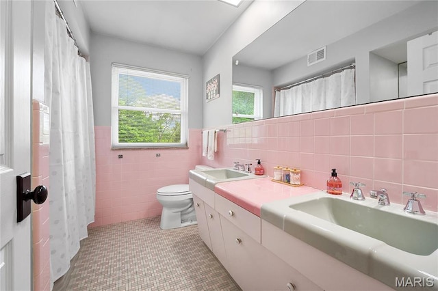 12935 Topping Estates Dr, Town And Country, MO 63131 - bathroom featuring tile walls, toilet, wainscoting, double vanity, and tile patterned floors
