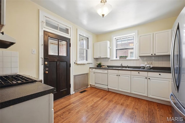 7350 Colgate Ave, University City, MO 63130 - kitchen with dishwasher, dark countertops, freestanding refrigerator, and tasteful backsplash