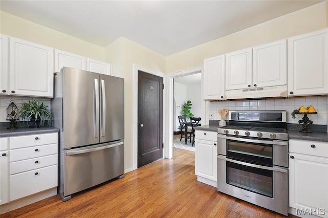 7350 Colgate Ave, University City, MO 63130 - kitchen with stainless steel appliances, under cabinet range hood, dark countertops, and white cabinets