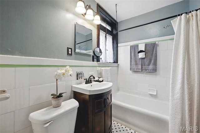 7350 Colgate Ave, University City, MO 63130 - full bathroom featuring vanity, toilet, shower / tub combo, tile walls, and a wainscoted wall