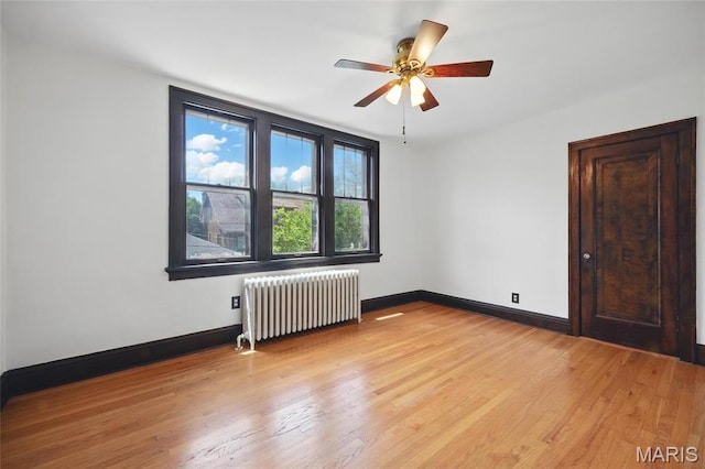 7350 Colgate Ave, University City, MO 63130 - unfurnished room featuring radiator heating unit, light wood-style floors, baseboards, and a ceiling fan
