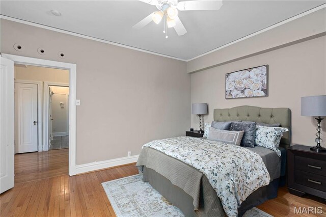 bedroom featuring baseboards, light wood finished floors, crown molding, and ceiling fan