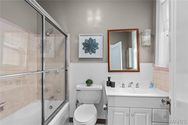 bathroom with vanity, enclosed tub / shower combo, and toilet