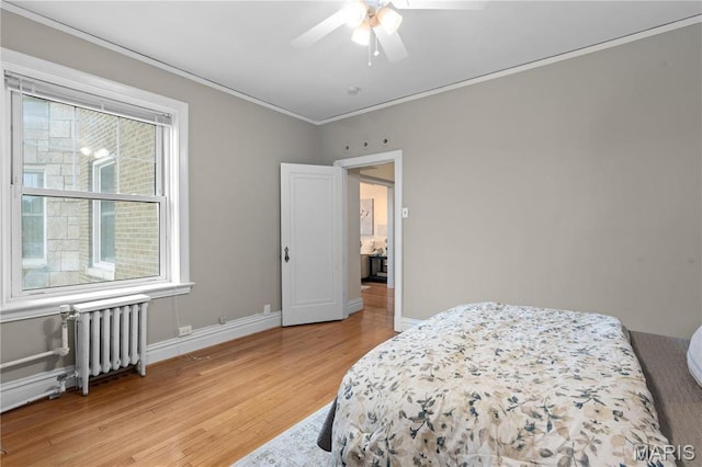bedroom featuring radiator heating unit, light wood finished floors, crown molding, baseboards, and a ceiling fan