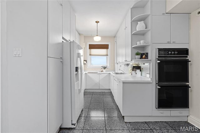 kitchen with white refrigerator with ice dispenser, open shelves, white cabinets, a sink, and light countertops