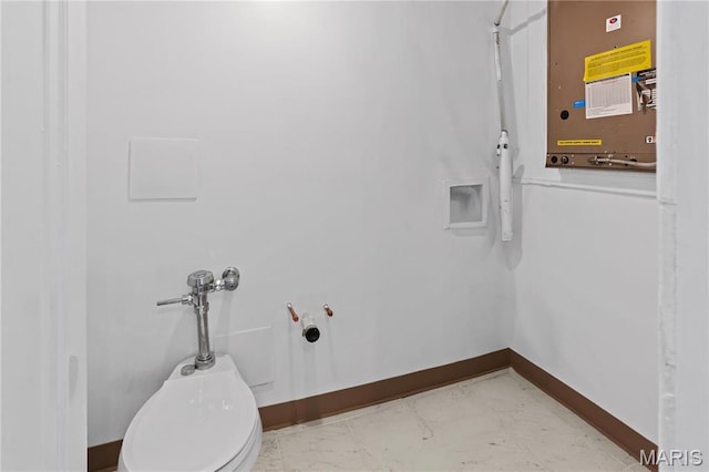 laundry room featuring baseboards and light marble finish floors