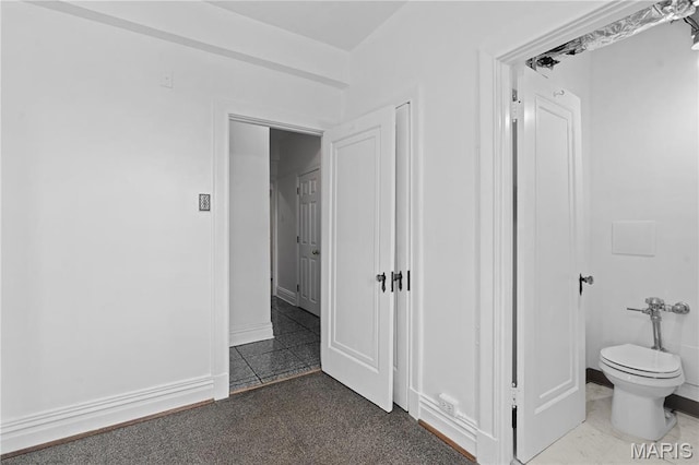 bathroom featuring toilet and baseboards