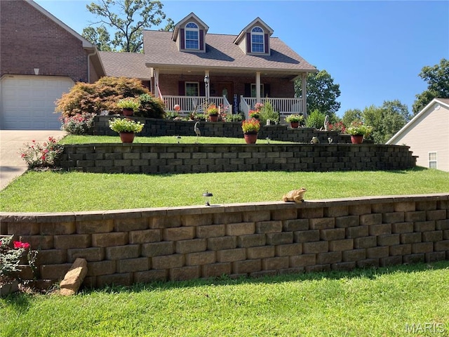 13 Montauk Ct, Leadington, MO 63601 - new england style home featuring an attached garage, concrete driveway, a front yard, and covered porch