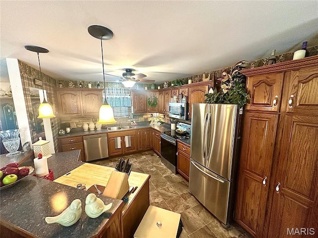 13 Montauk Ct, Leadington, MO 63601 - kitchen with appliances with stainless steel finishes, a ceiling fan, a sink, dark countertops, and hanging light fixtures