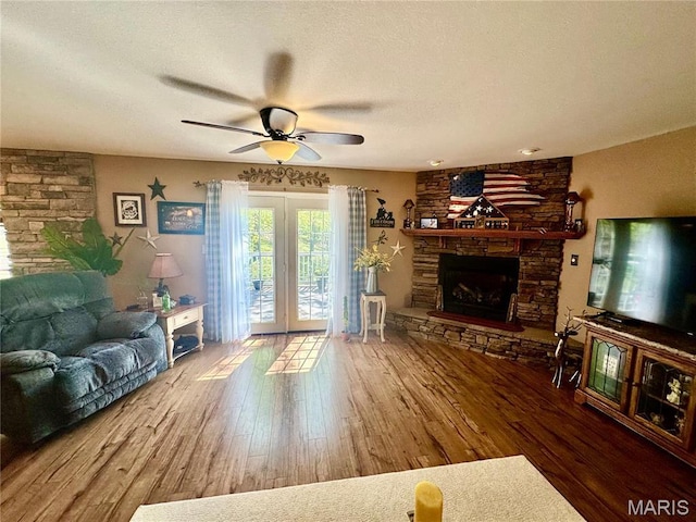13 Montauk Ct, Leadington, MO 63601 - living area featuring a fireplace, wood finished floors, ceiling fan, french doors, and a textured ceiling