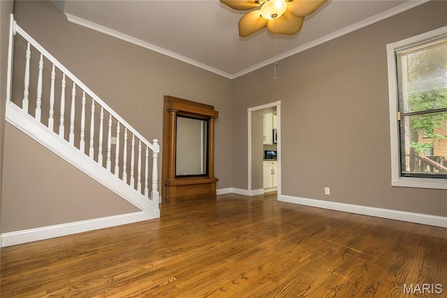1703 Carroll St, Saint Louis, MO 63104 - spare room with baseboards, ceiling fan, wood finished floors, ornamental molding, and stairs