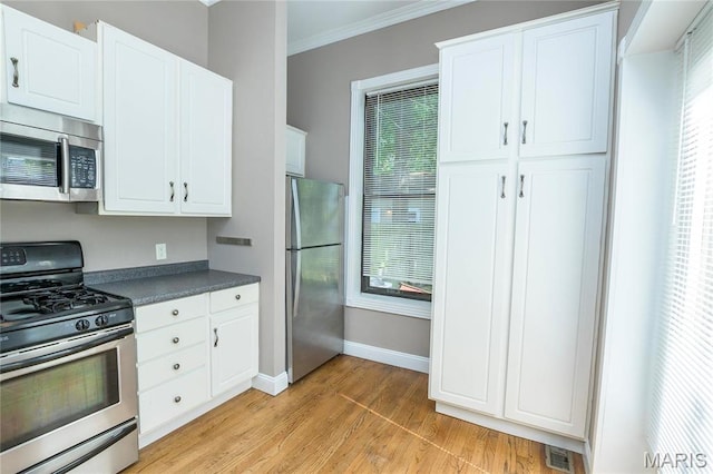 1703 Carroll St, Saint Louis, MO 63104 - kitchen with appliances with stainless steel finishes, dark countertops, ornamental molding, light wood-type flooring, and baseboards