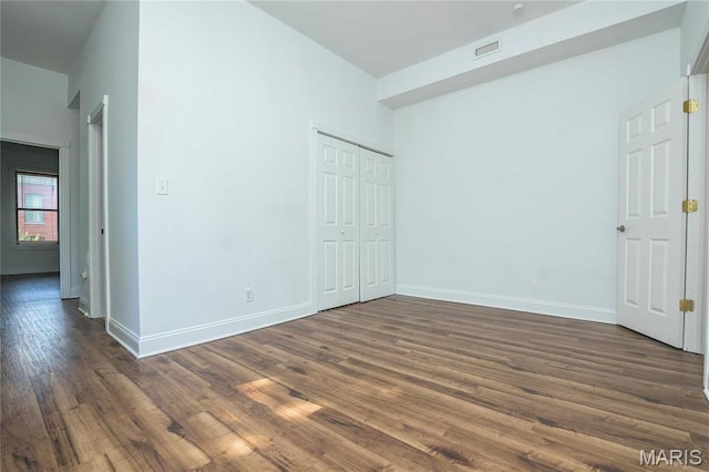 1703 Carroll St, Saint Louis, MO 63104 - unfurnished bedroom featuring dark wood-type flooring, baseboards, and a closet