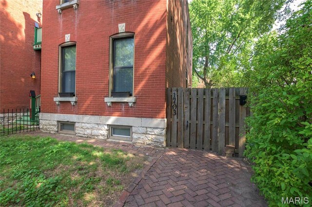 1703 Carroll St, Saint Louis, MO 63104 - view of side of property featuring brick siding and fence