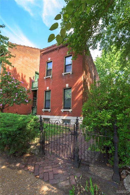 1703 Carroll St, Saint Louis, MO 63104 - view of front of house with fence and brick siding