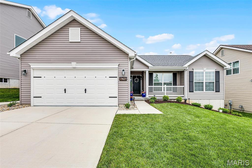 7421 Shadow Point Dr, Saint Louis, MO 63129 - single story home with covered porch, concrete driveway, a front yard, and a garage
