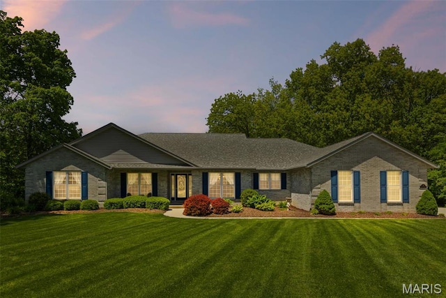ranch-style house with a front lawn and brick siding