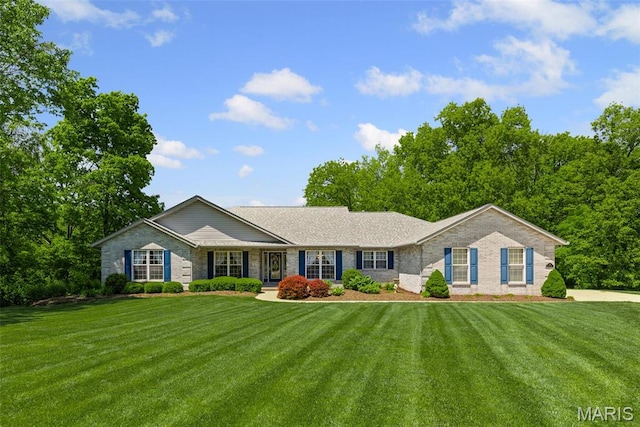 single story home featuring a front yard and brick siding