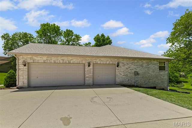 view of front of house with brick siding, concrete driveway, a garage, and a shingled roof