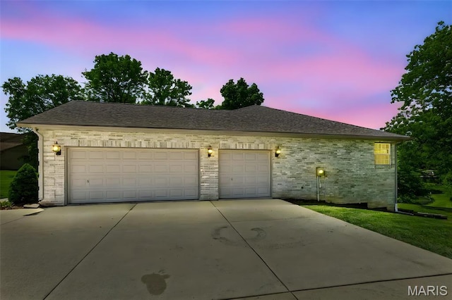 view of front facade with concrete driveway, brick siding, and a shingled roof