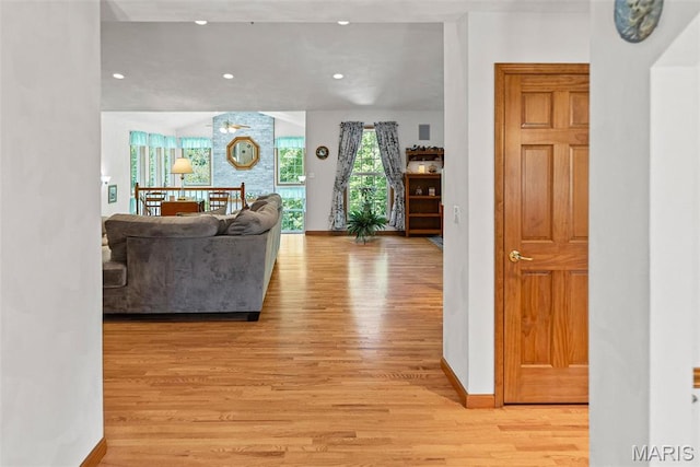 living area with light wood-style flooring, baseboards, and recessed lighting
