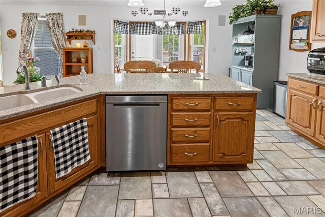 kitchen featuring stainless steel dishwasher, a sink, stone tile floors, a chandelier, and pendant lighting