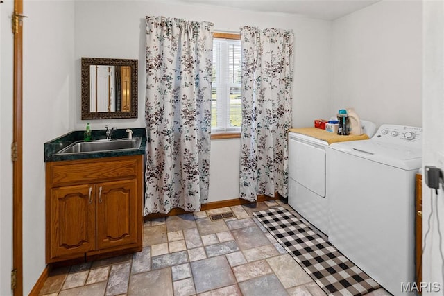 washroom with washing machine and dryer, baseboards, and light stone finish flooring