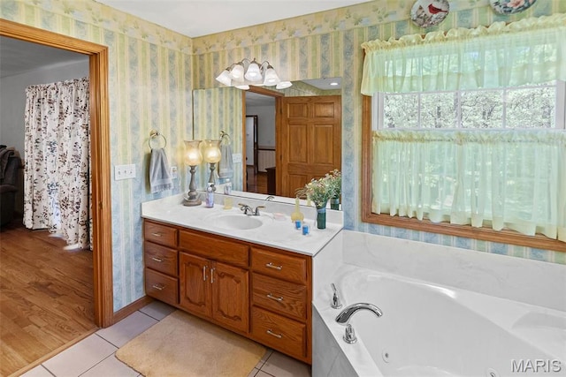 bathroom featuring wallpapered walls, a jetted tub, vanity, and tile patterned flooring
