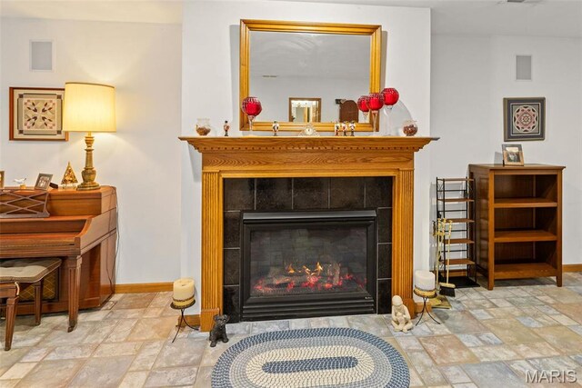 detailed view of baseboards and a tiled fireplace