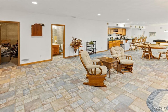 living area featuring baseboards and recessed lighting