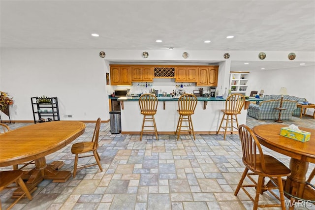 dining space with recessed lighting, baseboards, and light stone finish flooring