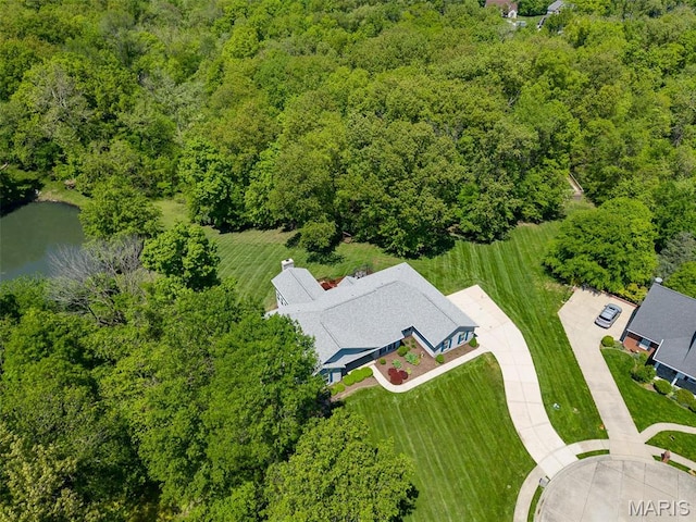 drone / aerial view of a heavily wooded area and a nearby body of water