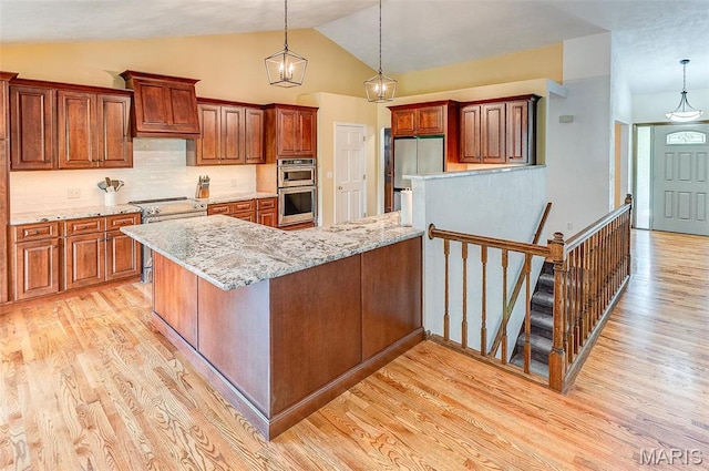 3708 Rhetts Lndg, Shiloh, IL 62221 - kitchen featuring appliances with stainless steel finishes, light wood finished floors, lofted ceiling, hanging light fixtures, and a peninsula