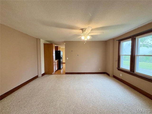 9621 Main St, Altenburg, MO 63732 - unfurnished room featuring a ceiling fan, a textured ceiling, light carpet, and baseboards