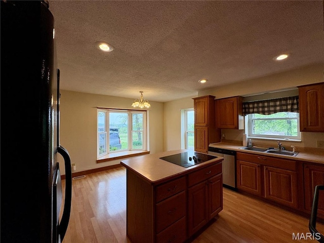 9621 Main St, Altenburg, MO 63732 - kitchen with black appliances, a sink, a textured ceiling, light wood-type flooring, and light countertops
