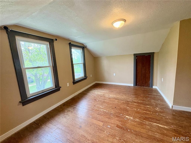 9621 Main St, Altenburg, MO 63732 - additional living space featuring lofted ceiling, a textured ceiling, hardwood / wood-style flooring, and baseboards