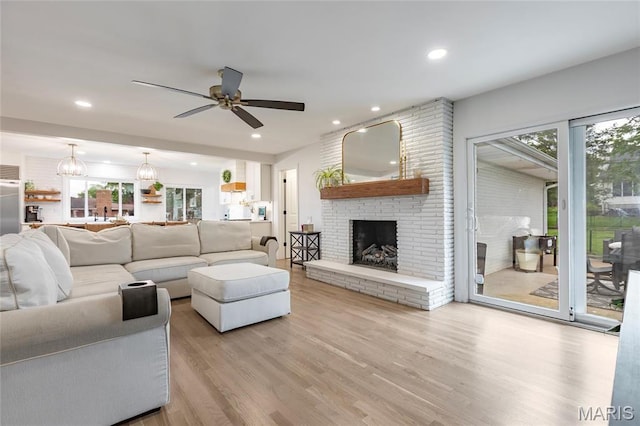 living room with healthy amount of natural light, wood finished floors, ceiling fan, a fireplace, and recessed lighting