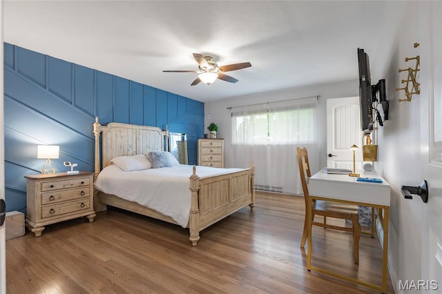 bedroom with wood finished floors, a ceiling fan, and baseboards
