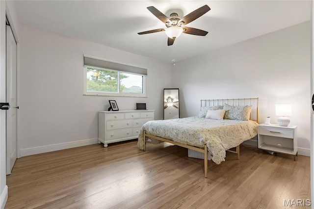 bedroom with baseboards, light wood-type flooring, and ceiling fan