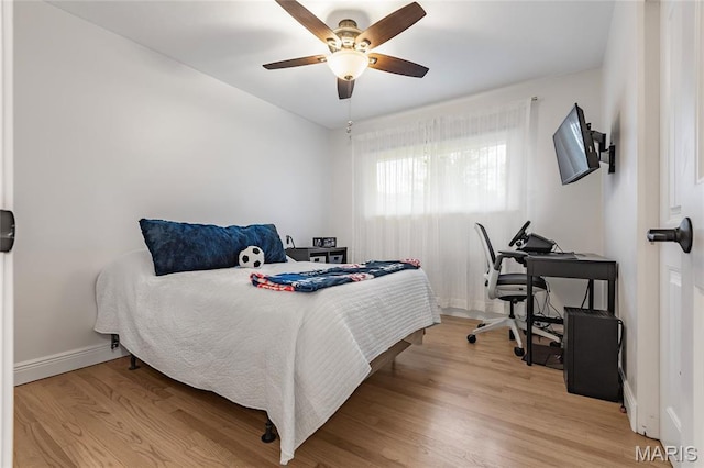 bedroom featuring wood finished floors, baseboards, and a ceiling fan