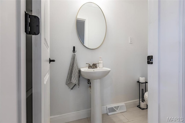 bathroom featuring baseboards and toilet