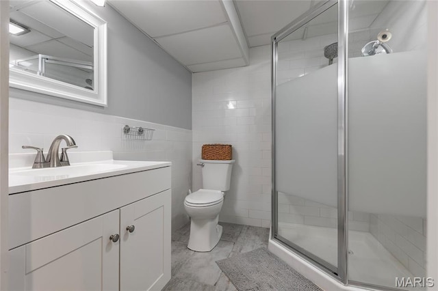 full bathroom featuring tile walls, a shower stall, vanity, and toilet