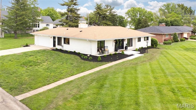 view of front of house featuring driveway, an attached garage, and a front lawn