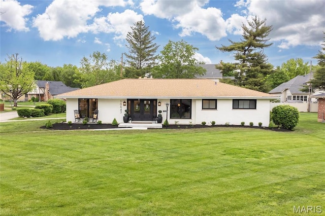 view of front facade featuring a front yard, stucco siding, and french doors
